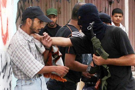 Members of Hamas forces arrest a Fatah party supporter